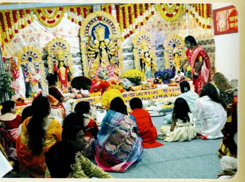 Devotees worshipping at a decorated Durga Puja altar